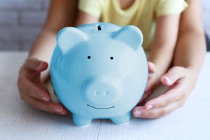 a person holding a blue piggy bank in their hands.